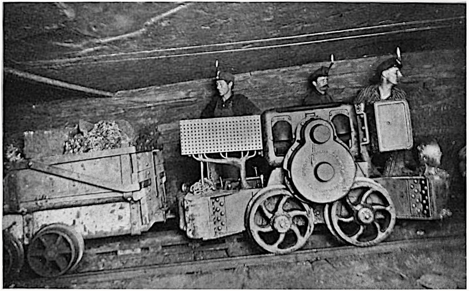 An archival black and white photo of coal miners at the start of their shift.